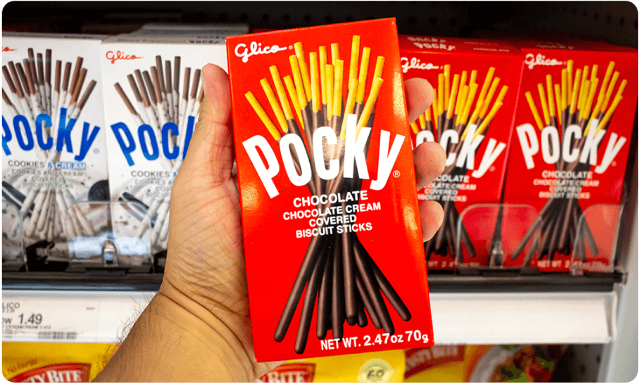 A person holding a box of chocolate Pocky.